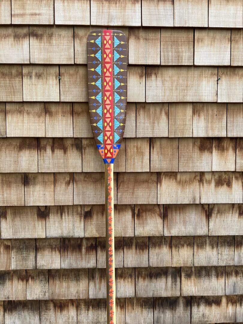 A wooden paddle with a colorful design on it.